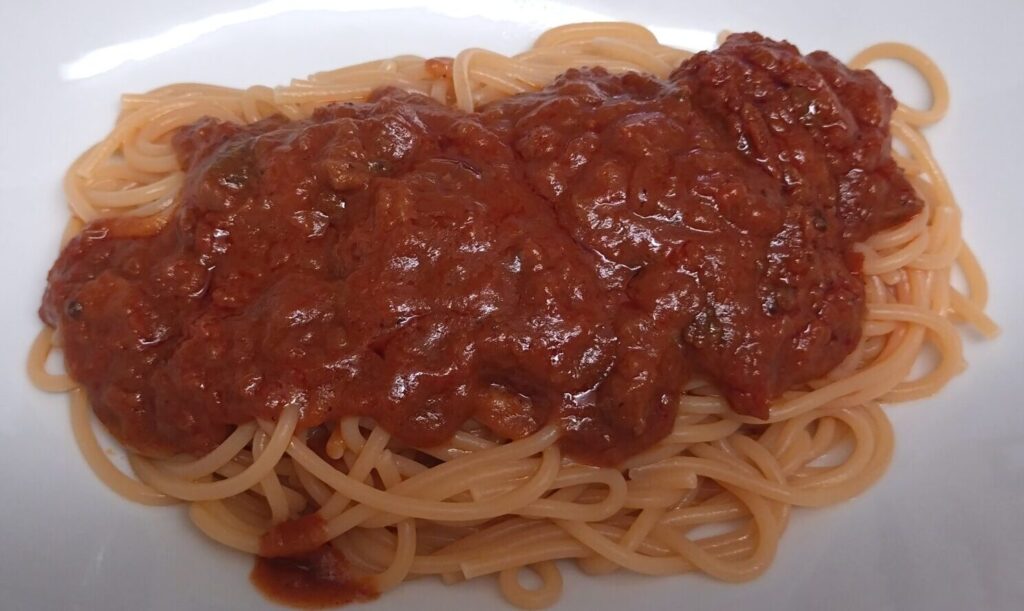ZENBヌードル丸麺に香味野菜のベジボロネーゼをかけた写真